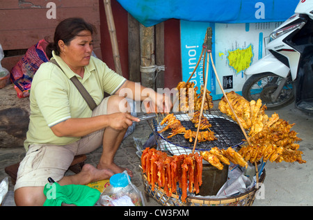 Lebensmittel Verkäufer grillen Fleisch über ein Holzkohle Feuer am Chaweng Beach auf der Insel Ko Samui, Thailand. Stockfoto