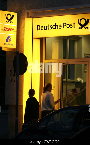 Kunden vor dem Eingang zu einem deutschen Postämtern Stockfoto