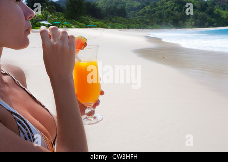 Frau im Badeanzug am Strand einen Cocktail zu trinken. Seychellen Stockfoto