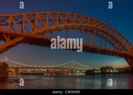 Die Hell Gate und Triborough Brücken überspannen die Hell Gate Gezeiten Meerenge im East River während der Abenddämmerung in New York City. Stockfoto