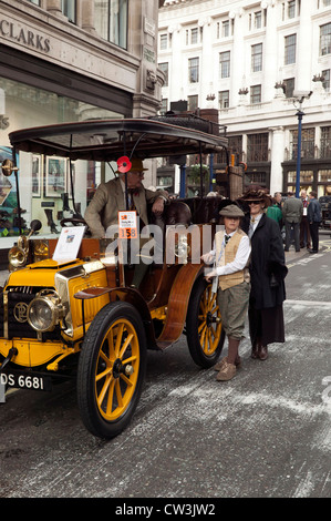 Familie Pose in historischen Kostümen neben ihrer 1902 Panhard Levassor. Stockfoto