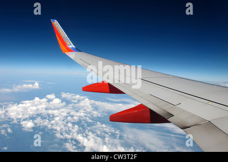 Blick auf einen klaren, blauen Himmel und weiße Wolken unterhalb von Southwest Airline Boeing 737 auf normalen Reiseflughöhe. Stockfoto