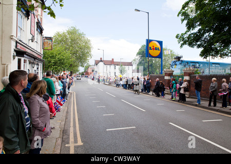 Menschenmengen säumen New Road, Willenhall, West Midlands, um im Laufe der Olympischen Fackel und seines Trägers zu erwarten Stockfoto