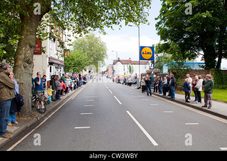 Menschenmengen säumen New Road, Willenhall, West Midlands, um im Laufe der Olympischen Fackel und seines Trägers zu erwarten Stockfoto