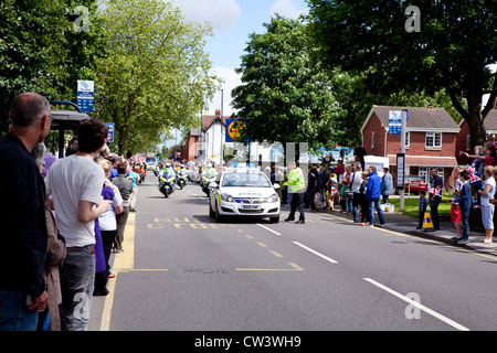 Menschenmassen line New Road, Willenhall, West Midlands, erwarten Sie im Laufe der Olympischen Fackel und seines Trägers führen durch die Polizei Stockfoto