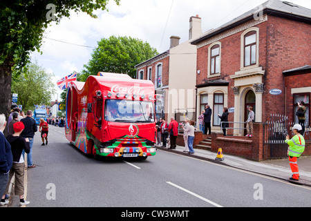 Menschenmengen säumen New Road, Willenhall, West Midlands, um die Weitergabe von die Olympische Fackel und seines Trägers vorangestellt Sponsoren erwarten Stockfoto