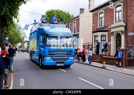 Menschenmengen säumen New Road, Willenhall, West Midlands, um die Weitergabe von die Olympische Fackel und seines Trägers vorangestellt Sponsoren erwarten Stockfoto