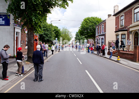 Menschenmengen säumen New Road, Willenhall, West Midlands, um im Laufe der Olympischen Fackel und seines Trägers zu erwarten Stockfoto