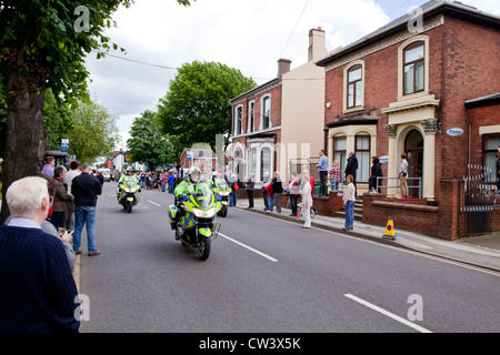 Menschenmassen line New Road, Willenhall, West Midlands, erwarten Sie im Laufe der Olympischen Fackel und seines Trägers führen durch die Polizei Stockfoto