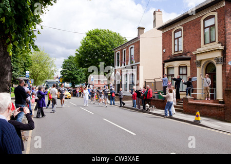 Ein olympischer Fackelträger rinnt New Road, Willenhall, West Midlands, als Teil der London 2012 Olympische Fackel Relais Route. Stockfoto