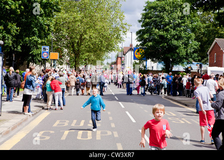 Massen zu zerstreuen und Kleinkinder laufen in Richtung der Verabschiedung Fackelträger der Olympischen Fackel an der New Road, Willenhall Stockfoto