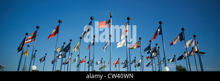 Es gibt 50 staatlichen Flaggen wehten im Wind auf Fahnenmasten gleich weit entfernten auseinander gegen blauen Himmel mit amerikanischen Flagge im Zentrum. Diese Stockfoto