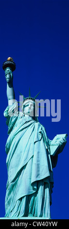Dies ist eine vertikale Aufnahme der Statue of Liberty vor blauem Himmel. Stockfoto