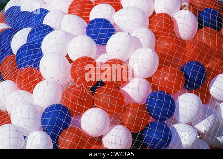 Rote, weiße und blaue Ballons durch Netz statt Stockfoto