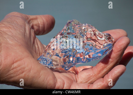 Mann hält Stück Eis vom Mendenhall Gletscher Stockfoto
