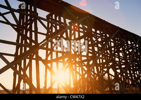 Roten Sonnenuntergang durchschimmern Gerüst der Hochbahn-Brücke Stockfoto