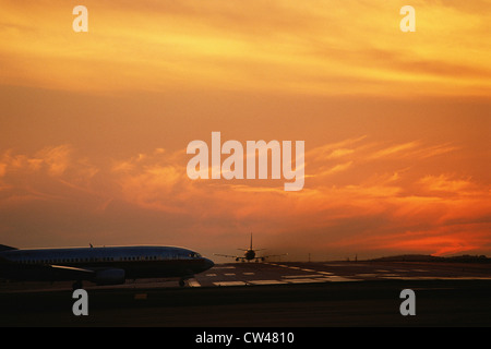 Flugzeuge auf der Piste bei Sonnenuntergang Stockfoto