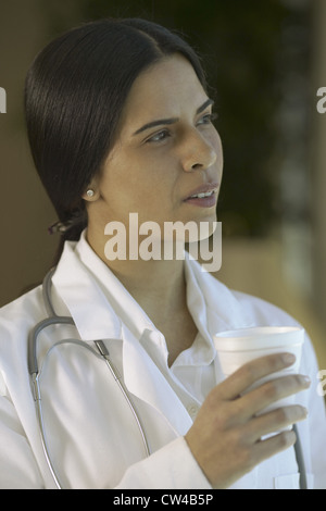 Seitenansicht von einer Ärztin hält eine Tasse Stockfoto