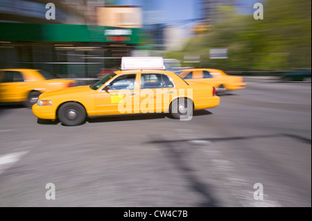Verschwommene gelben Taxis Geschwindigkeit um in Manhattan, New York City, New York Stockfoto