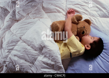 Jungen schlafen mit einem Teddy-Bären Stockfoto