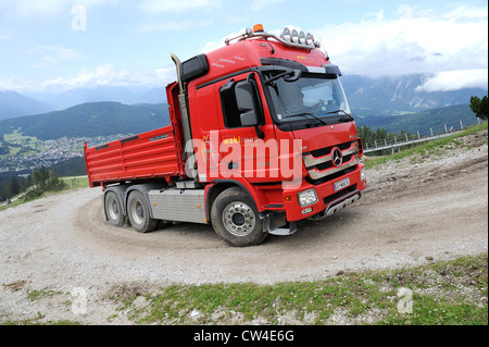 Mercedes Actros vier Rädern fahren-Kipper-LKW fahren einen geschotterten Mountain Track, Material zu einer Skistation zu liefern. Stockfoto