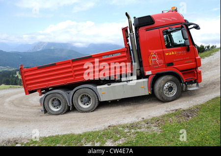 Mercedes Actros vier Rädern fahren-Kipper-LKW fahren einen geschotterten Mountain Track, Material zu einer Skistation zu liefern. Stockfoto