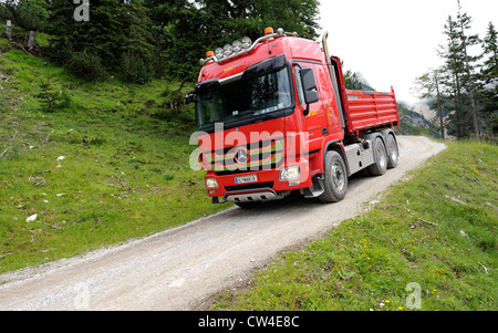 Mercedes Actros vier Rädern fahren-Kipper-LKW fahren einen geschotterten Mountain Track, Material zu einer Skistation zu liefern. Stockfoto