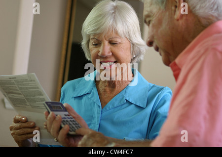 Ältere Mann mit einem Rechner mit einer älteren Frau neben ihm sitzen Stockfoto