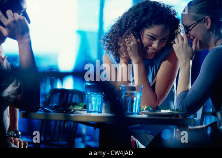 Zwei junge Frauen und ein junger Mann geht in ein restaurant Stockfoto