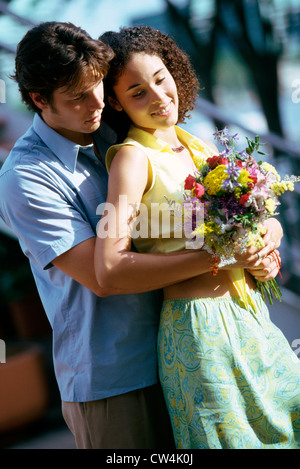 Junger Mann ein junges Mädchen von hinten umarmen Stockfoto