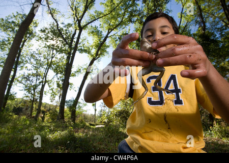 Porträt der fröhliche junge am Steg sitzen und halten Angeln am See Stockfoto