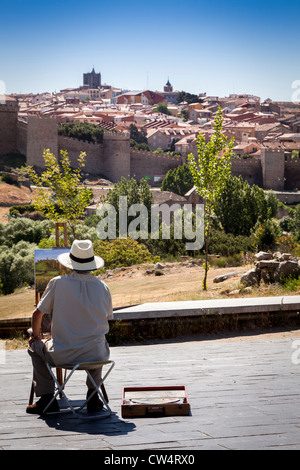 Künstler malen eine Szene der Befestigung zu den mittelalterlichen Stadtmauern von Ávila unter einem strahlend blauen Himmel, Spanien SA. Stockfoto