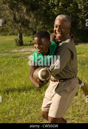 Vater mit seinem Sohn halten Fußball am Wald Stockfoto