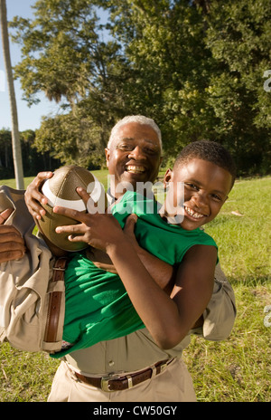 Porträt eines Vaters mit seinem Sohn halten Fußball am Wald Stockfoto