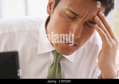 Nahaufnahme eines Kaufmanns unter Kopfschmerzen leiden Stockfoto