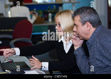 Unternehmensleiter diskutieren vor einem Laptop, Florida, USA Stockfoto