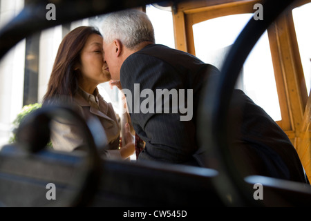 Älteres Paar küssen einander auf einer Straßenbahn, San Francisco, Kalifornien, USA Stockfoto