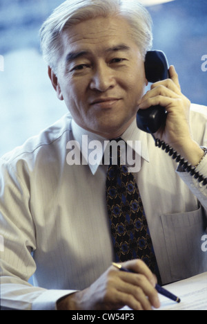 Porträt eines Geschäftsmannes sprechen auf ein Festnetz-Telefon Stockfoto