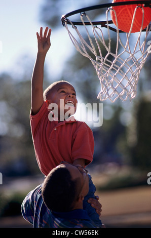 Vater und Sohn spielen basketball Stockfoto