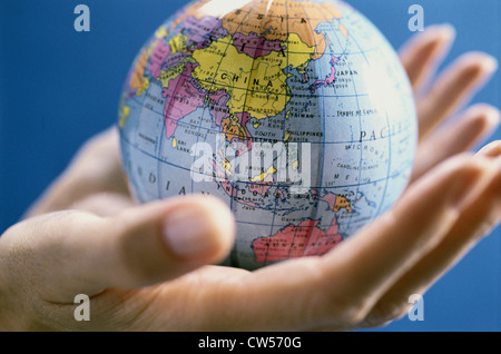 Eine Person, die Hände halten einen Globus in Nahaufnahme Stockfoto