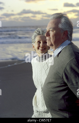 Älteres paar lächelnd am Strand Stockfoto