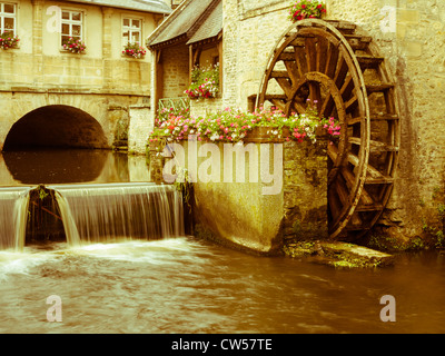 Ein Wasserrad an einer historischen mittelalterlichen Mühle am Fluss Aure, Bayeux in der Normandie Frankreich durchfließt. Stockfoto