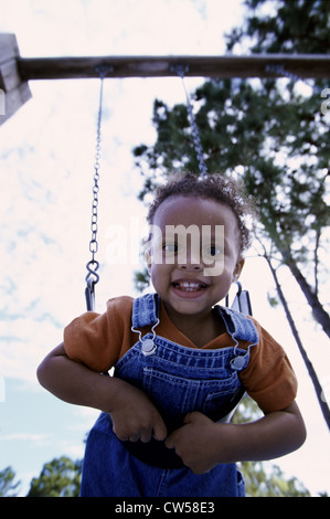 Bildnis eines Knaben sitzen auf einer Schaukel Stockfoto
