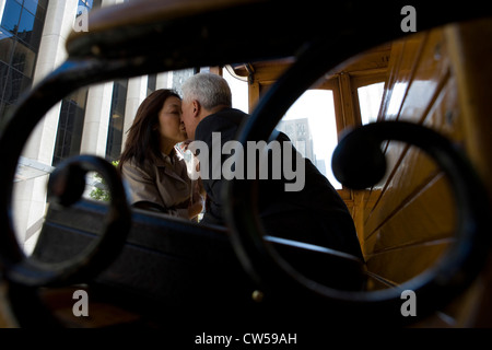 Älteres Paar küssen einander auf einer Straßenbahn, San Francisco, Kalifornien, USA Stockfoto