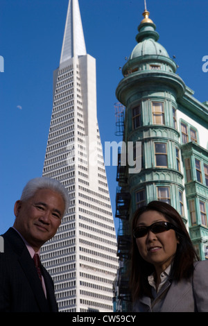 Niedrigen Winkel Ansicht Geschäftsmann und Geschäftsfrau stehend vor Gebäuden Transamerica Pyramid und Columbus Tower San Francisco Stockfoto
