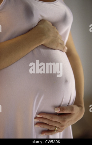 Mitte Schnittansicht einer schwangeren jungen Frau berühren ihres Bauches Stockfoto