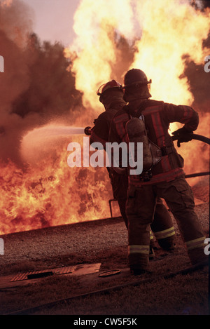 Rückansicht des zwei Feuerwehrleute, die Löscharbeiten Stockfoto