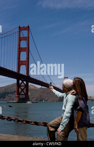Reifer Mann unter Bild Hängebrücke mit Reife Frau, die hinter ihm stehenden Golden Gate Brücke San Francisco Kalifornien Stockfoto