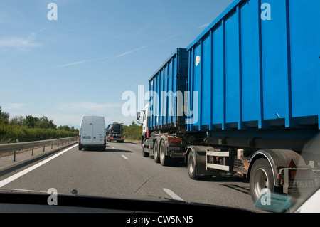 Große LKW & Trailer gesehen durch die Windschutzscheibe des Autos auf der französischen Autobahn Stockfoto