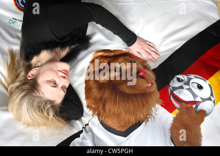 Lächelnde junge Frau mit WM-Maskottchen Goleo auf Leinen Stockfoto